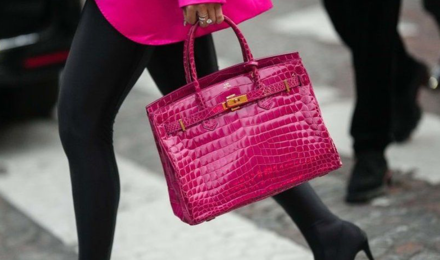 Person walking with a pink Hermes Birkin bag, showcasing luxury Hermes bags.